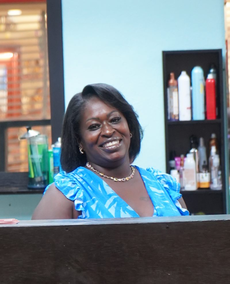 Lora Cross smiling behind the welcome desk