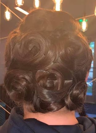 Formal updo with dark brown hair styled into rose curls